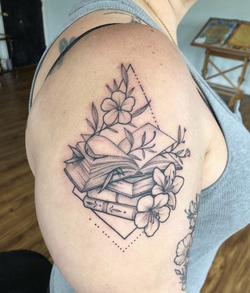 books, flowers, and geometric shapes in black and grey on outside upper arm